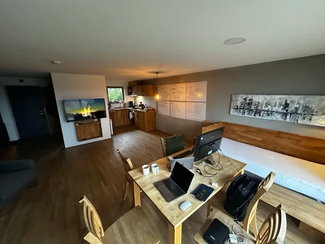 Workspace in the holiday flat at Lake Constance: wooden table with laptops, a monitor and coffee mugs, whiteboard sheets on the wall